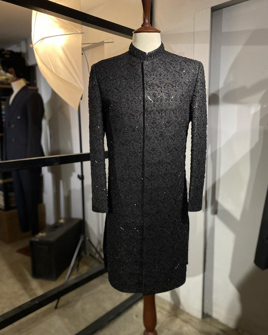 MAHARAJAH black raw silk sherwani with self embroidery and hand kora-dabka work. Best sherwani for groom & dulha—perfect for a bold, royal wedding look.