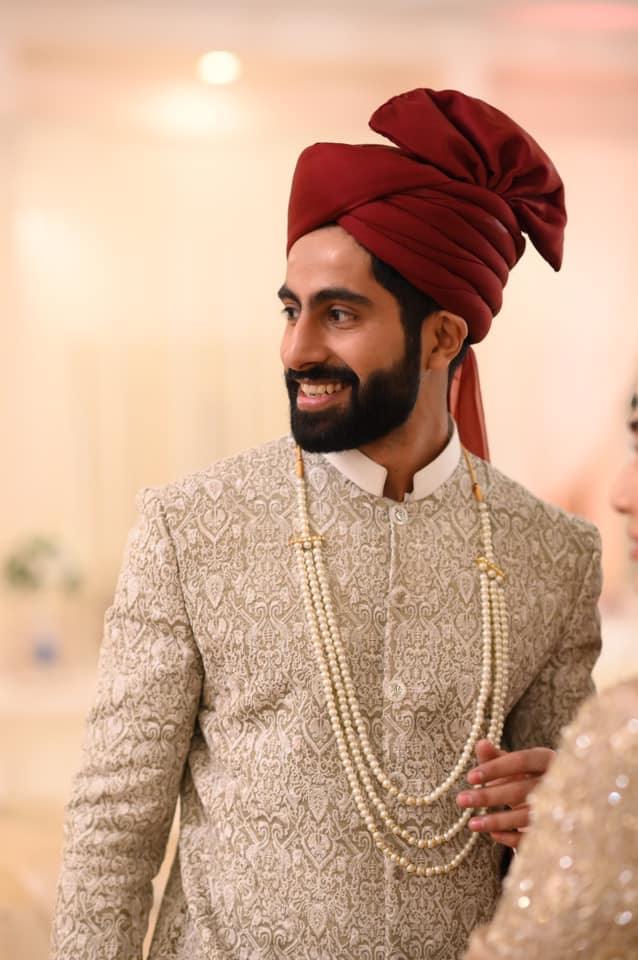 Groom wearing offwhite self embroidered sherwani with maroon turban